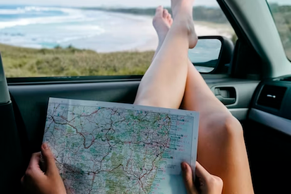 Mulher dentro de carro com mapa em mãos 